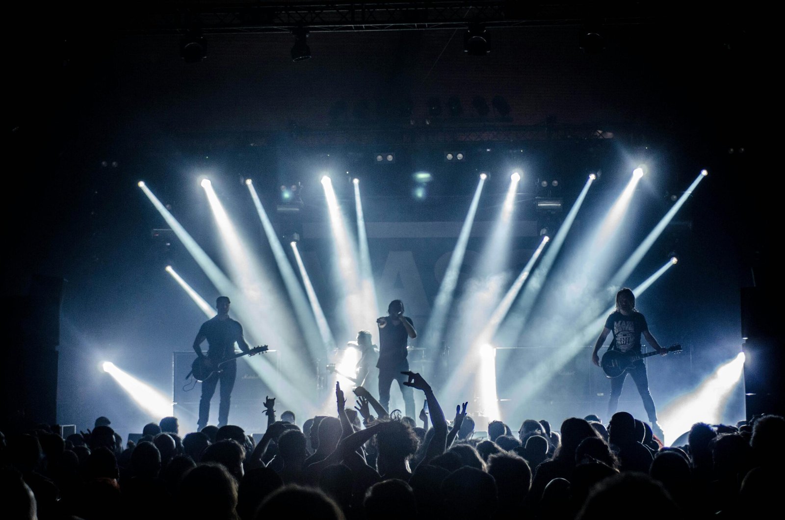Sube tu Arte Hombres en un concierto en vivo con músicos, en escenario y luces intensas frente al público